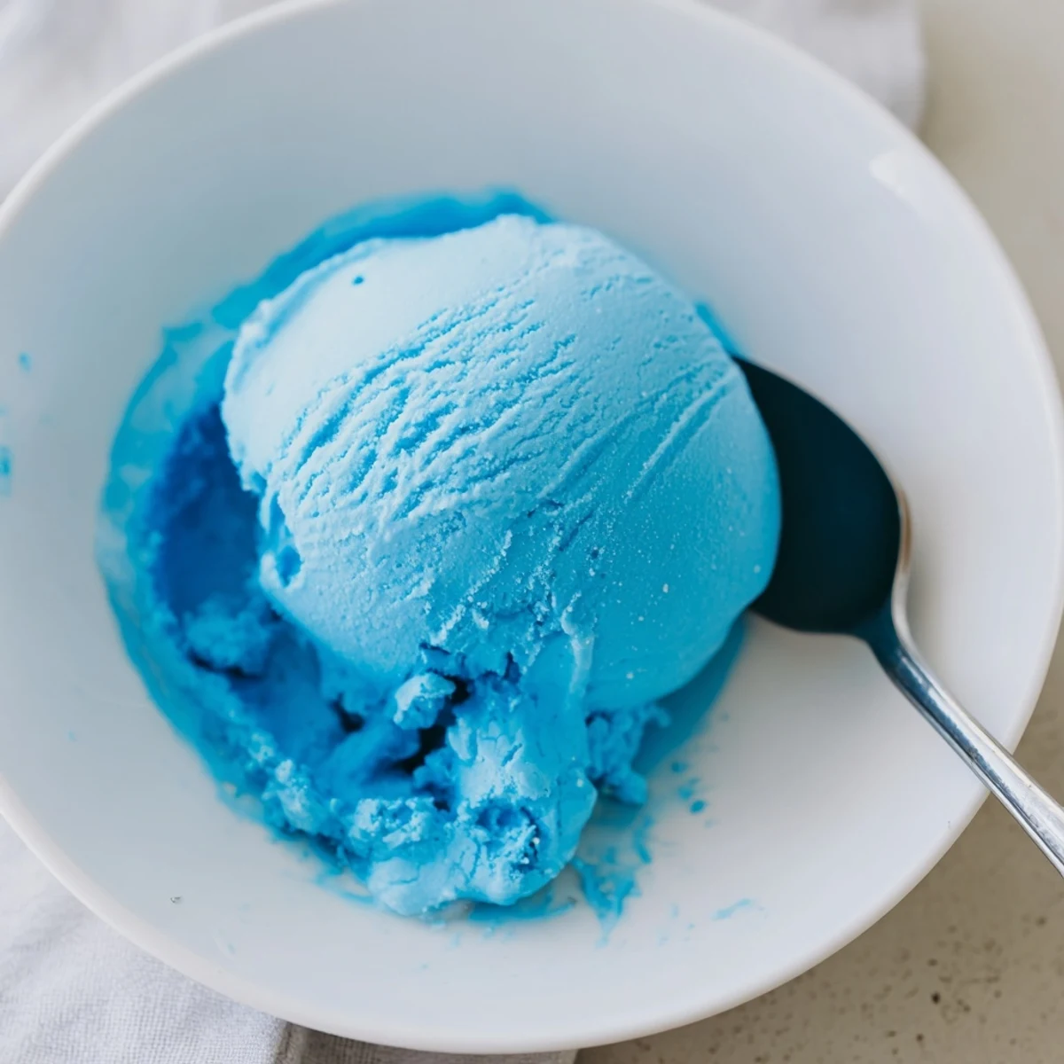 Creamy Blue Moon ice cream scooped into a crispy waffle cone with colorful sprinkles