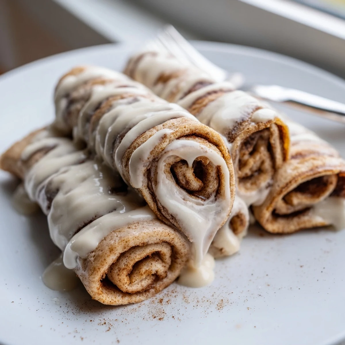 Thin protein-packed crepes layered with warm cinnamon sugar filling and topped with cream cheese drizzle