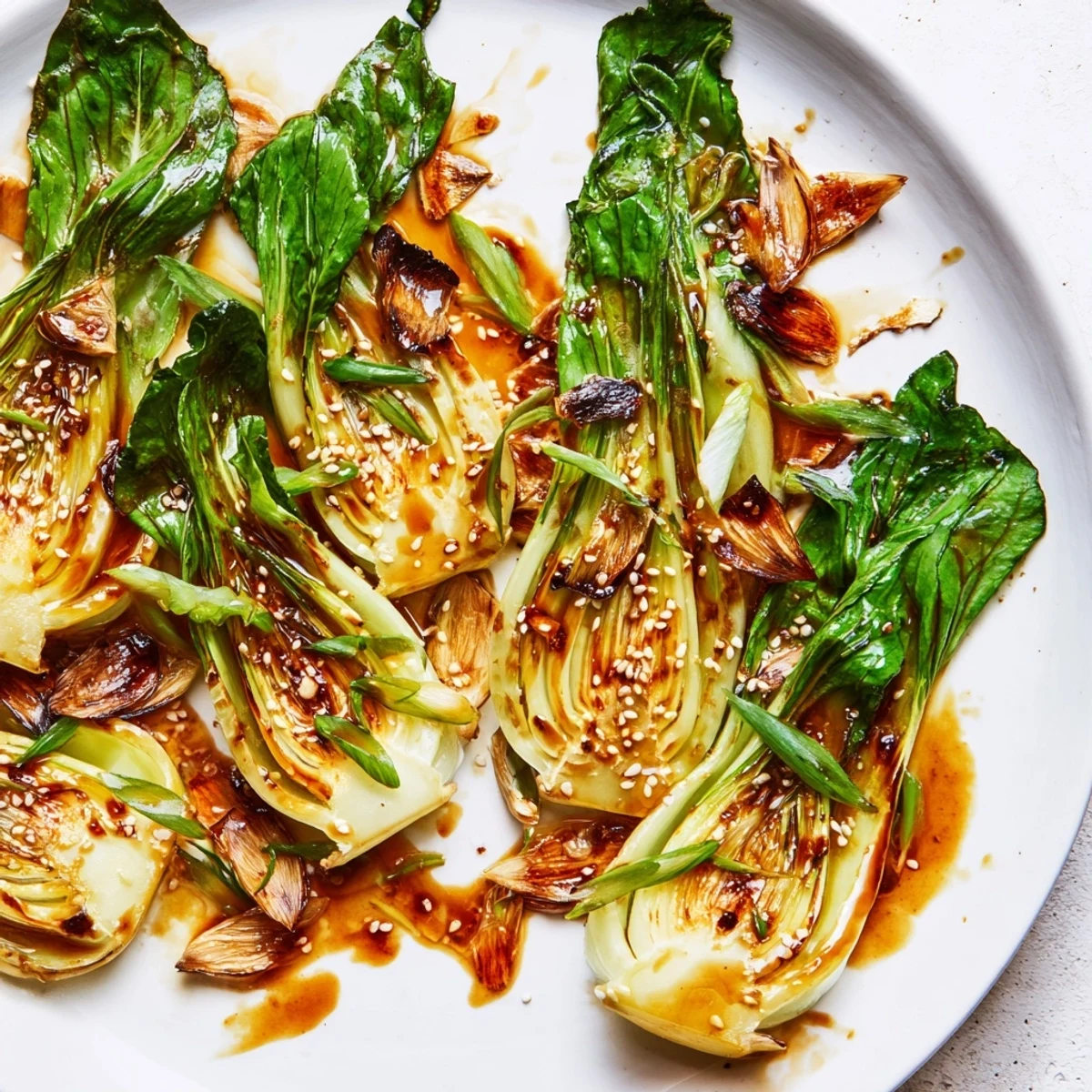 Caramelized Garlic Bok Choy with golden seared edges and glossy soy-maple glaze on a white platter