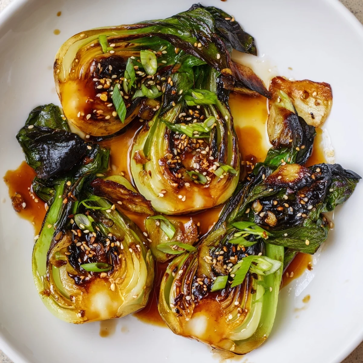 Tender Caramelized Garlic Bok Choy glistening with sesame oil and topped with crispy garlic chips