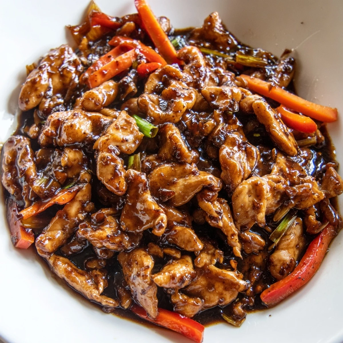 Garlicky stir fried Chinese garlic chicken sizzling in a wok with crisp vegetables