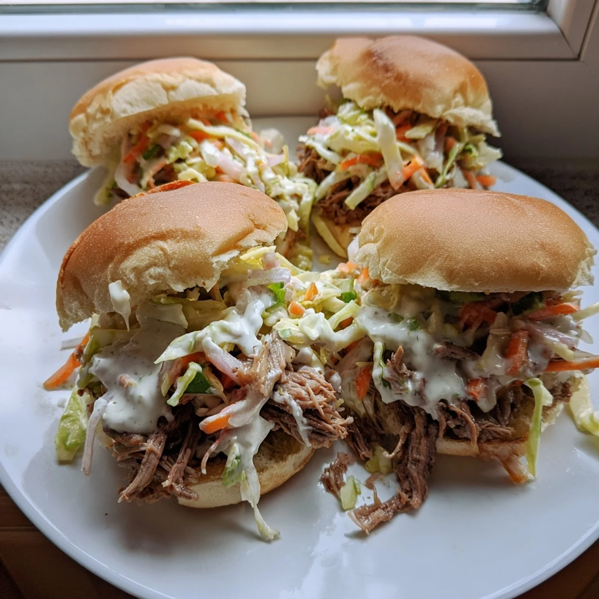 Creamy Alabama white sauce drizzled over tender pulled lamb sliders with crunchy slaw