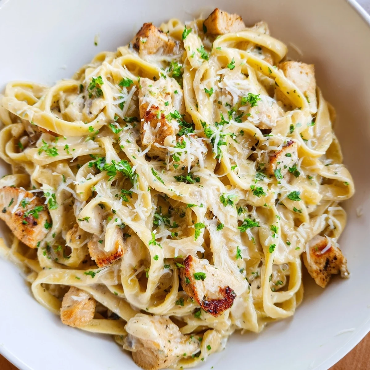 Steaming bowl of creamy garlic Parmesan chicken pasta with a golden creamy sauce