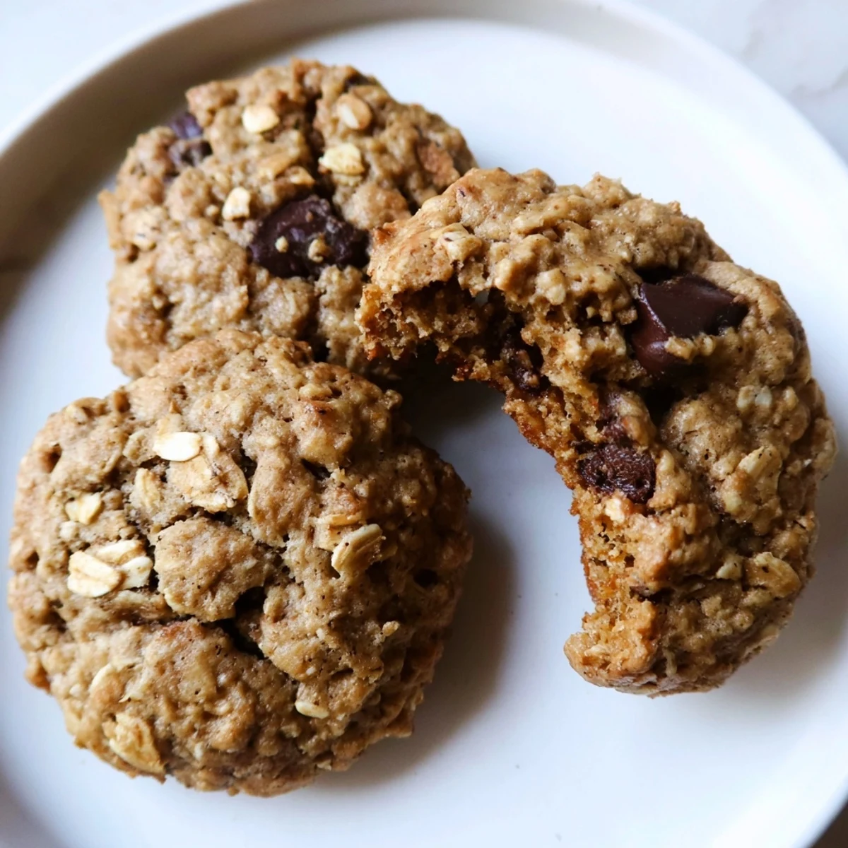 Chewy Banana Oatmeal Cookies with golden edges cooling on a rustic wire rack