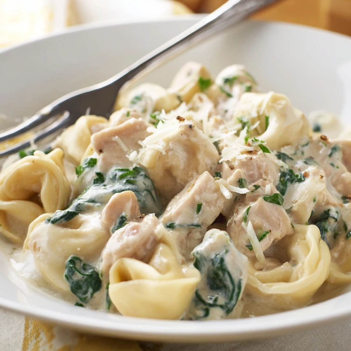 Golden seared chicken and cheese tortellini tossed in a silky garlic cream sauce with wilted spinach