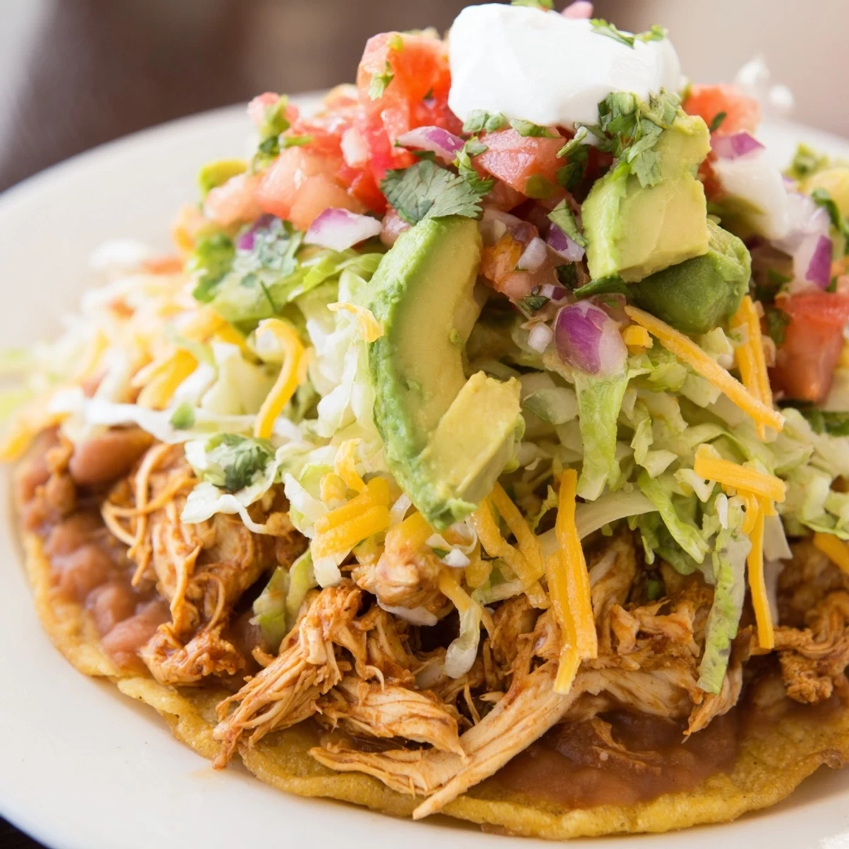 Golden corn tortillas piled high with juicy chicken and creamy avocado slices.  