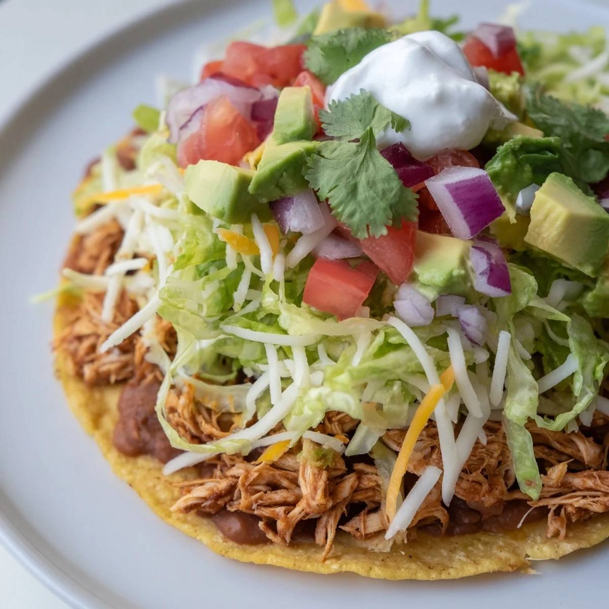 Ultimate Chicken Tostadas featuring crisp shells, savory beans, and zesty lime garnish.