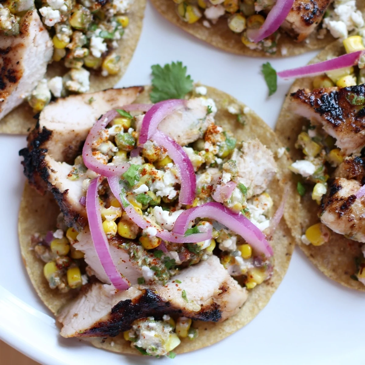 Vibrant street corn chicken tacos topped with creamy corn and fresh cilantro  