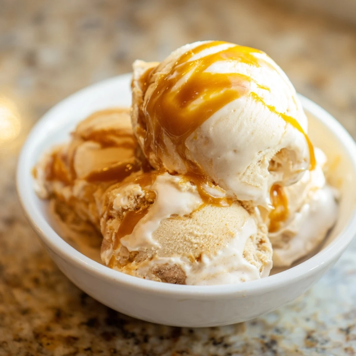 Scoop of creamy no churn salted caramel ice cream with caramel swirls.  